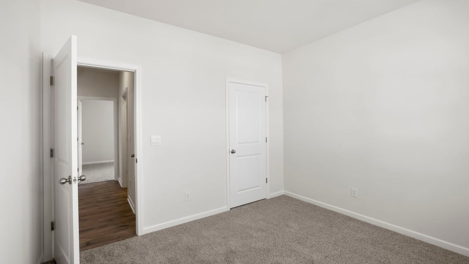 Bedroom with carpet and windows.