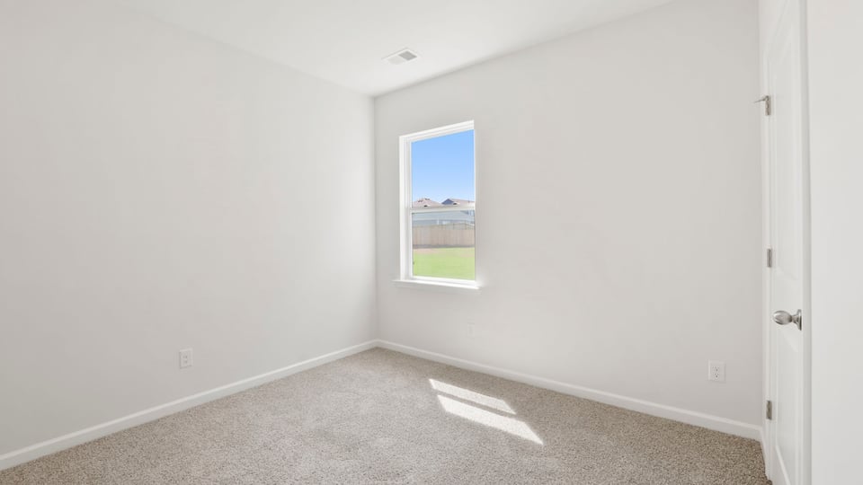 Bedroom with carpet and windows.