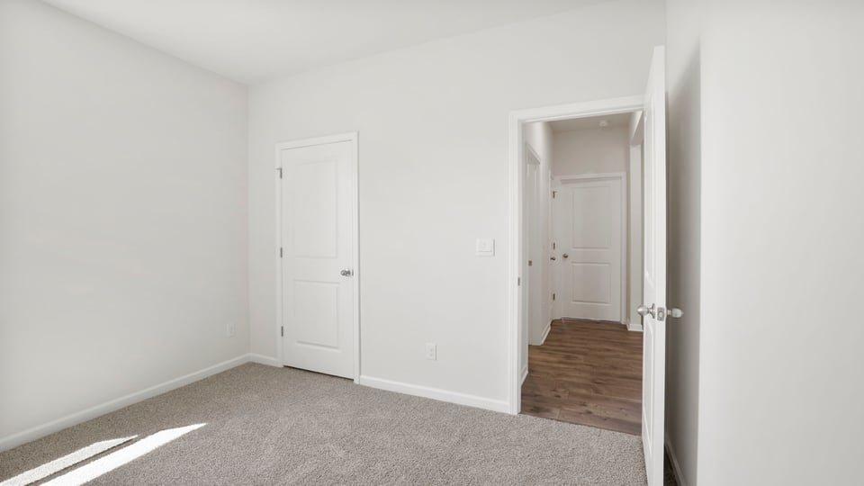 Bedroom with carpet and windows.