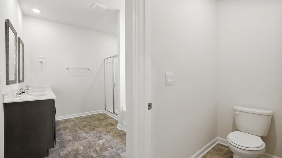 Primary bedroom with carpet and windows.