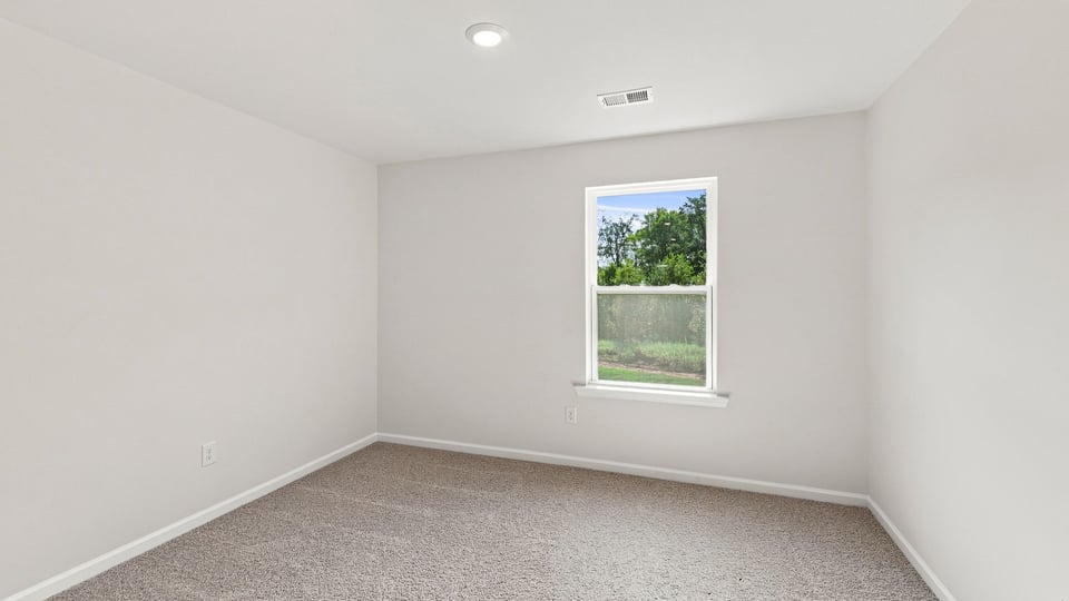 Bedroom with carpet and windows.