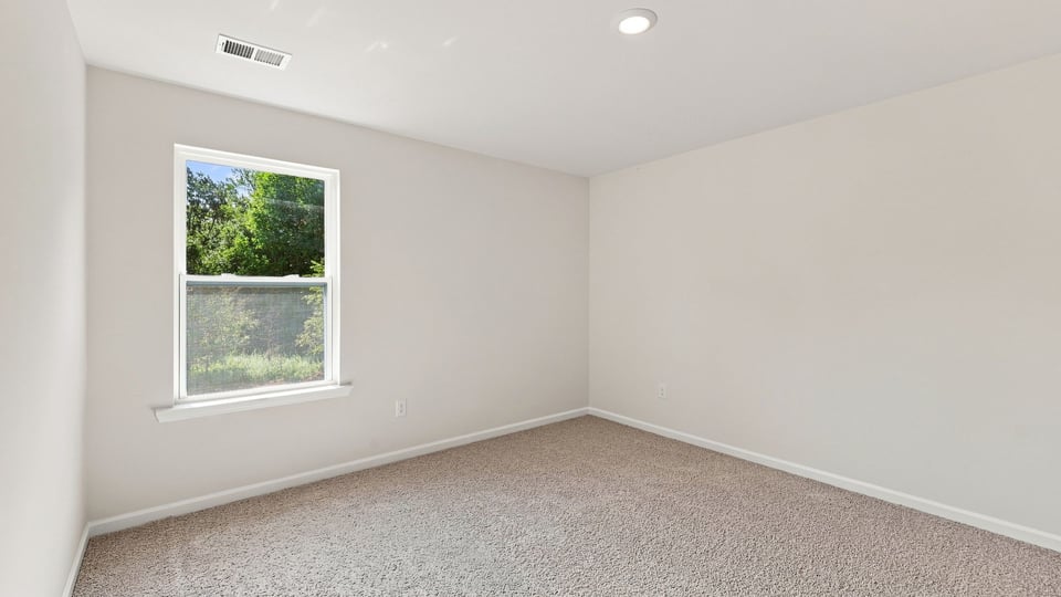 Bedroom with carpet and windows.