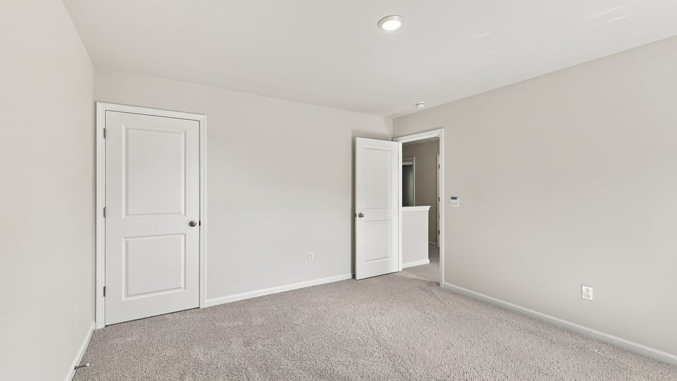 Bedroom with carpet and windows.