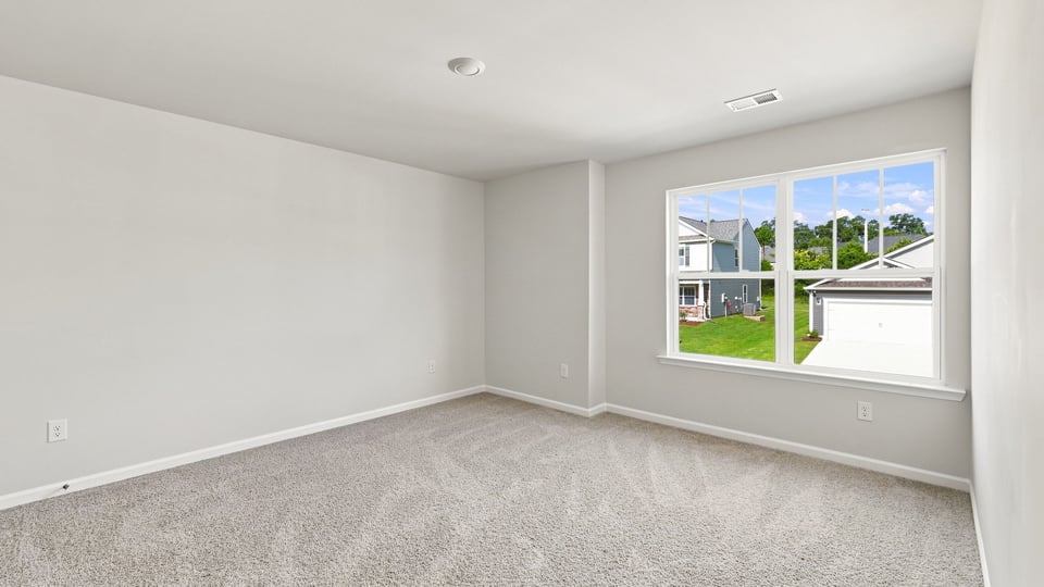Bedroom with carpet and windows.