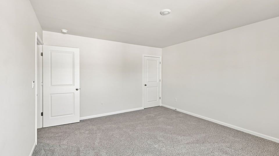 Bedroom with carpet and windows.