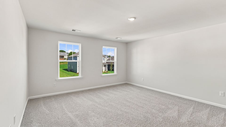 Bedroom with carpet and windows.