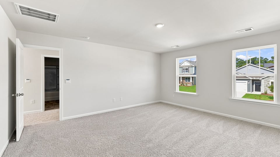 Bedroom with carpet and windows.