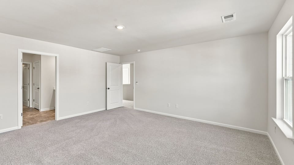 Bedroom with carpet and windows.