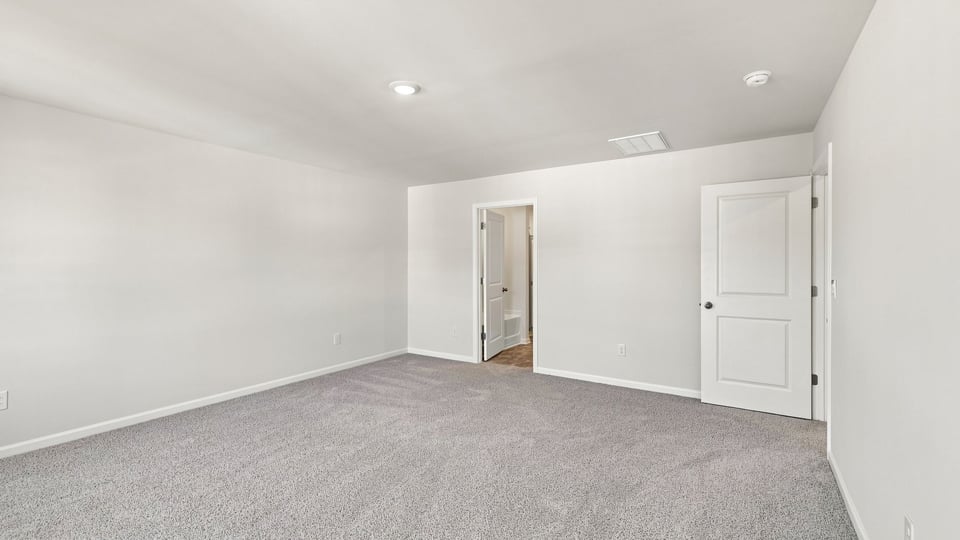 Bedroom with carpet and windows.