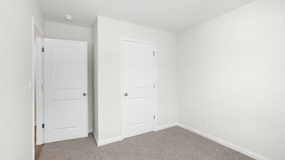 Bedroom with carpet and window.