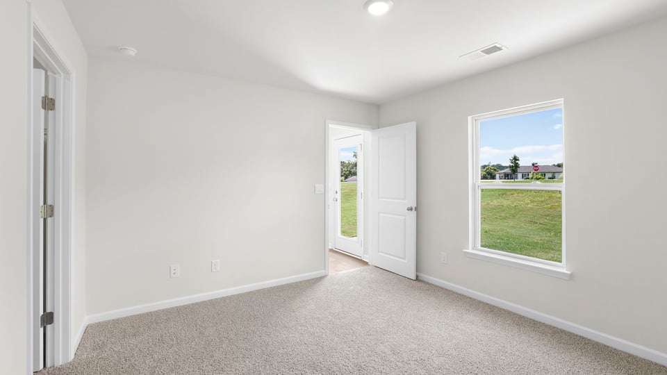 Bedroom with carpet and window.