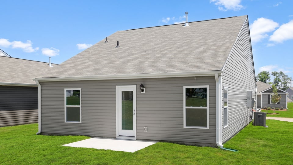 Large backyard of home with covered patio.