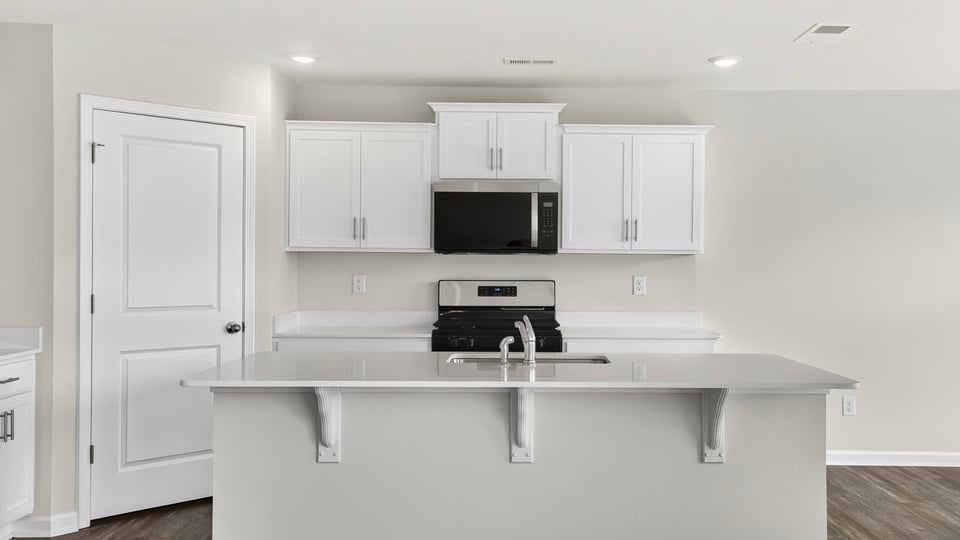 Kitchen and island with quartz countertops.