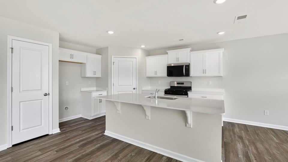 Kitchen and island with quartz countertops.