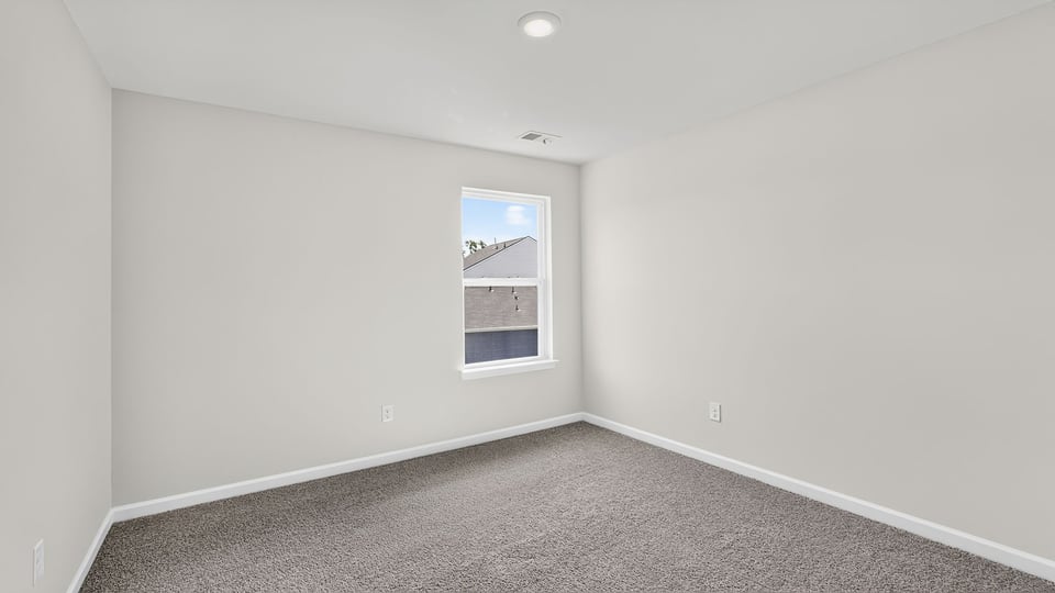Bedroom with carpet and window.