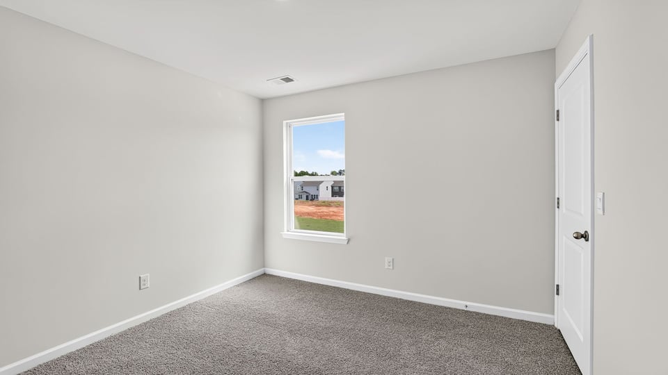 Bedroom with carpet and window.