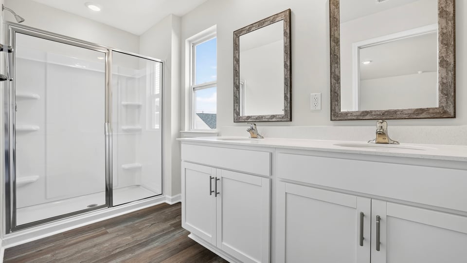 Bathroom with double vanity sink and walk in shower.