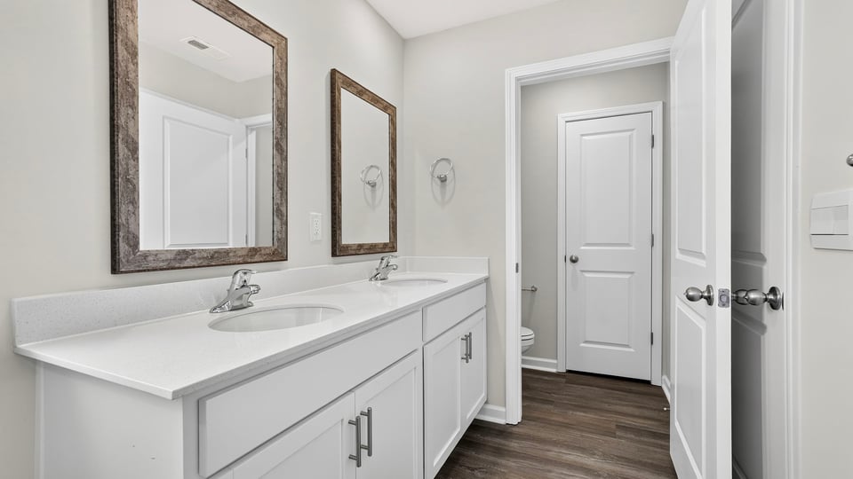 Bathroom with double vanity sink and walk in closet.
