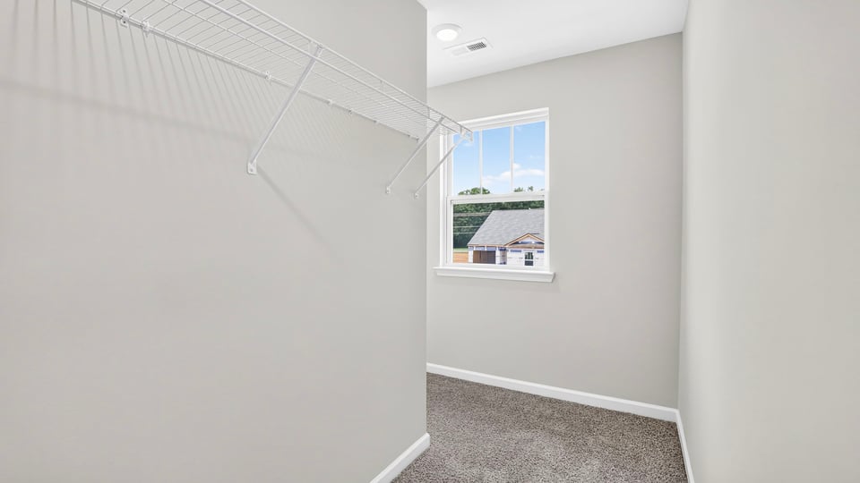 Closet with carpet and window.