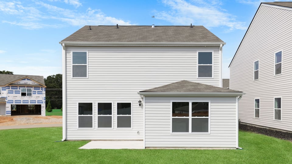 Back exterior of home with large backyard.