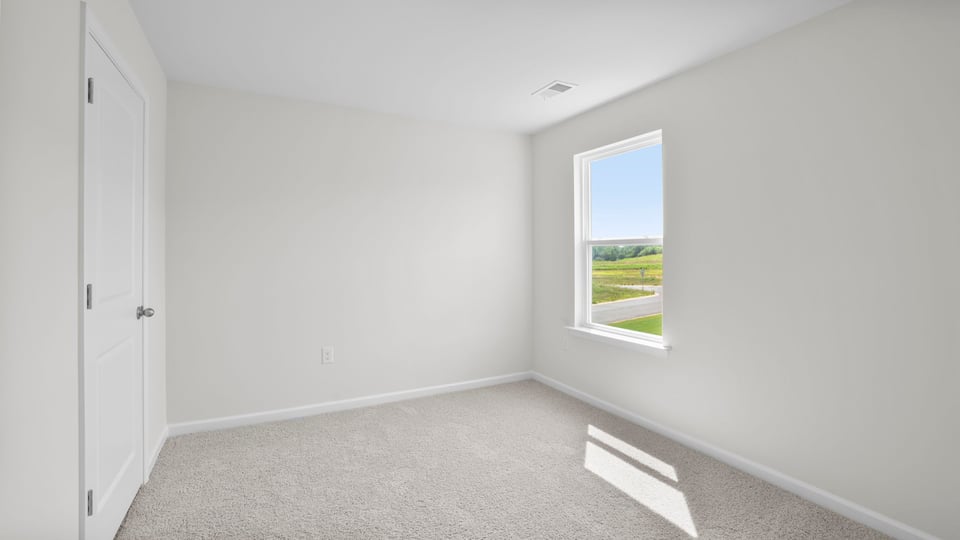 Bedroom with carpet and window.