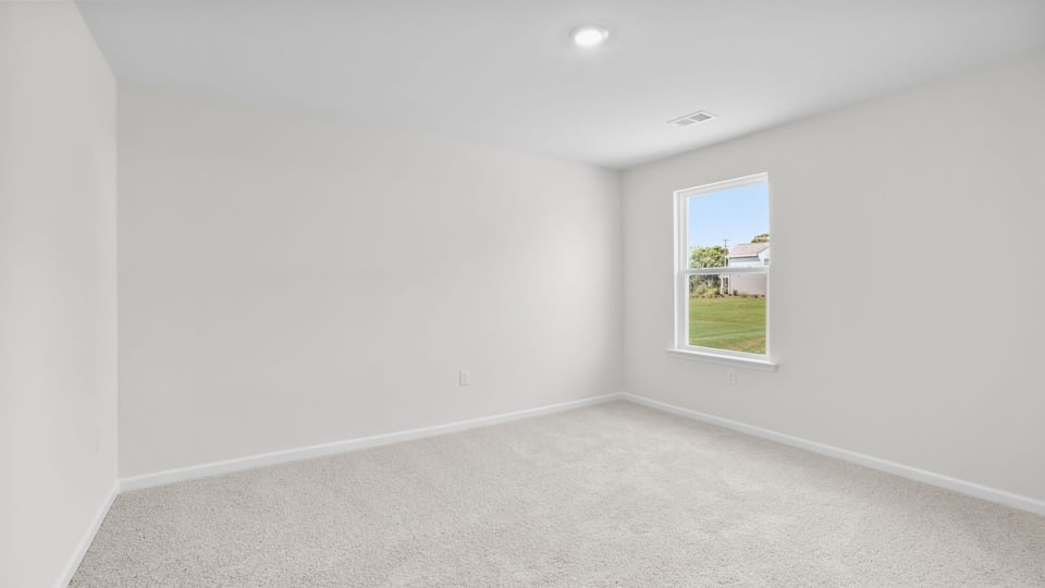 Bedroom with carpet and window.