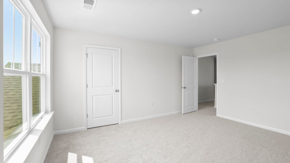 Bedroom with carpet and window.