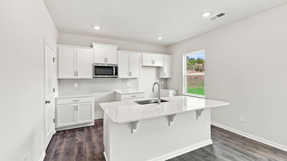 Kitchen and island with quartz countertops.
