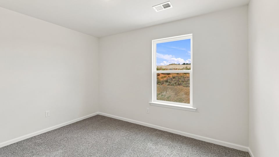 Bedroom with carpet and window.