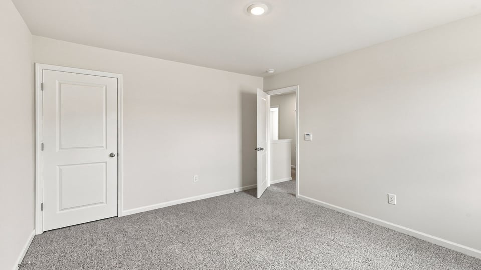 Bedroom with carpet and window.