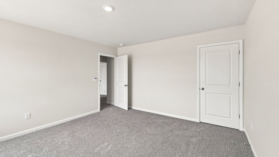 Bedroom with carpet and window.