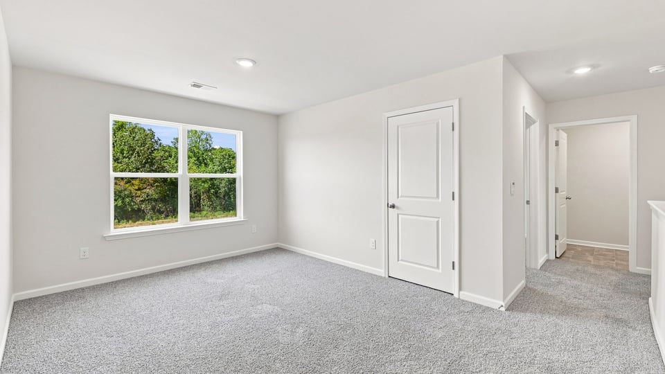 Bedroom with carpet and windows.