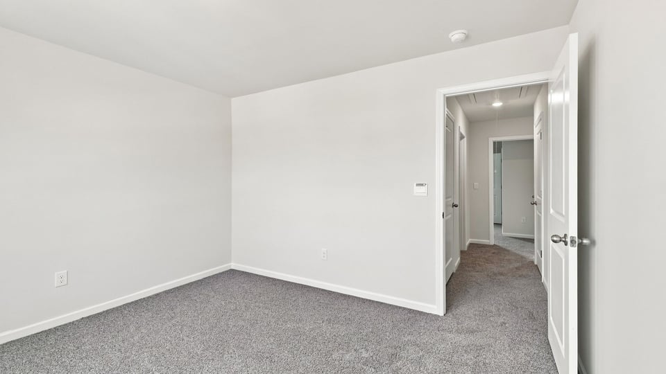 Bedroom with carpet and windows.
