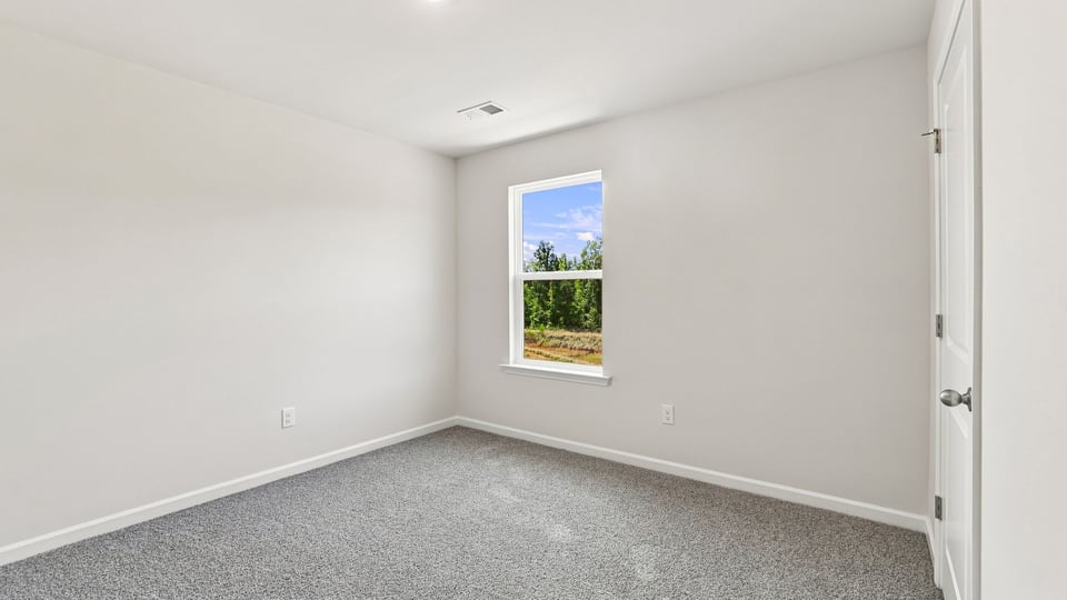 Bedroom with carpet and windows.