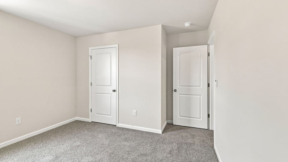 Bedroom with carpet and windows.