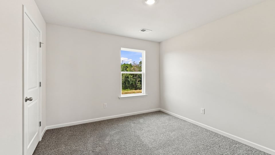 Bedroom with carpet and windows.