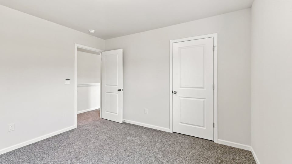 Bedroom with carpet and windows.