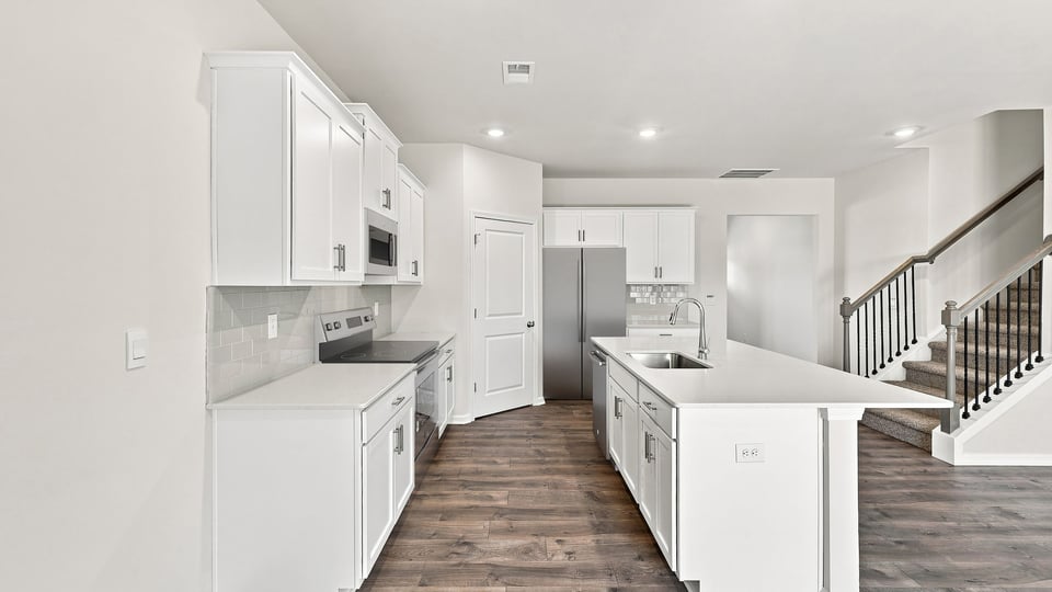 Kitchen and island with quartz countertops.