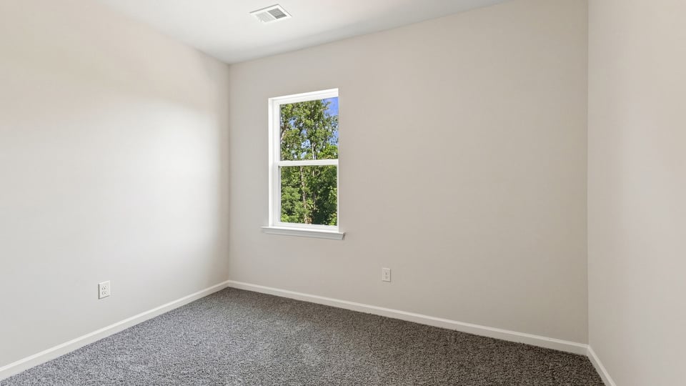 Bedroom with carpet and window.