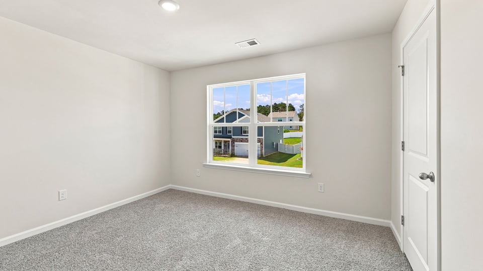 Bedroom with carpet and window.