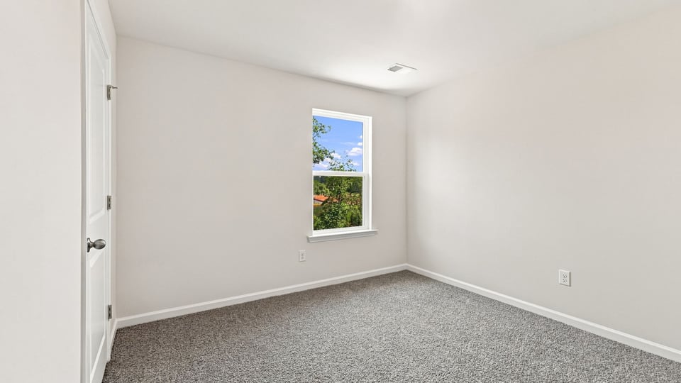 Bedroom with carpet and windows.