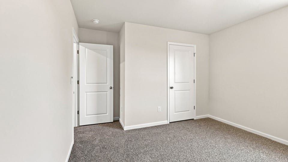 Bedroom with carpet and windows.