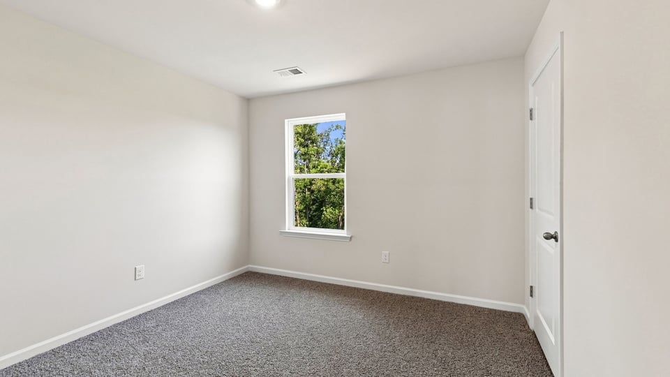 Bedroom with carpet and windows.