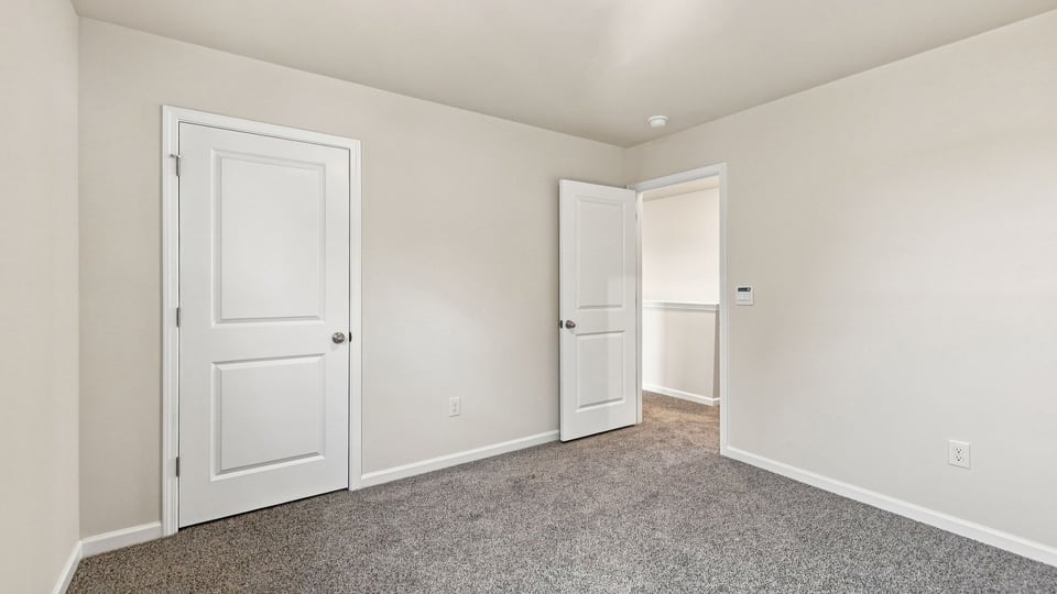 Bedroom with carpet and windows.