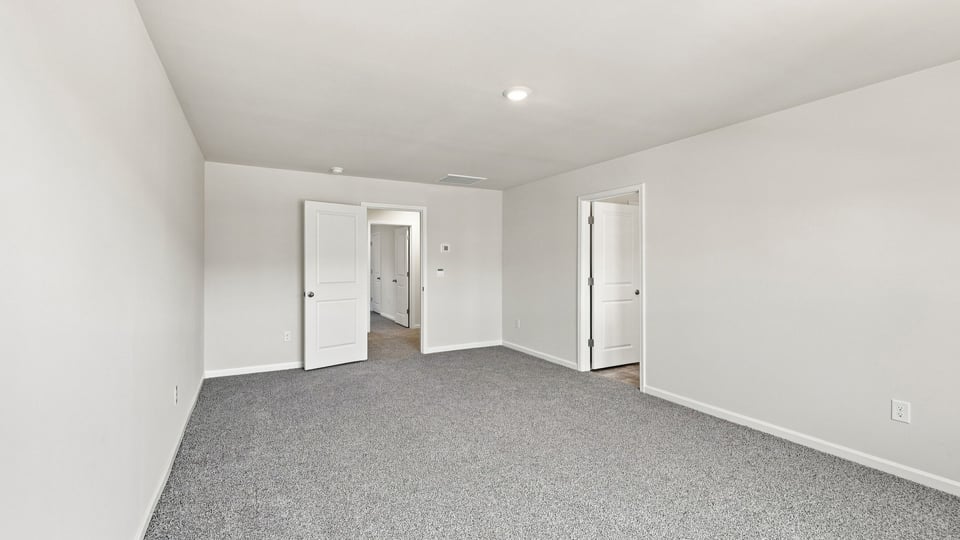 Bedroom with carpet and windows.