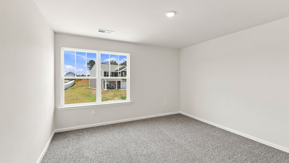 Bedroom with carpet and window.