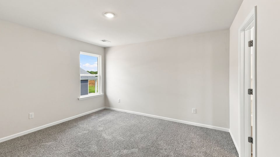 Bedroom with carpet and window.