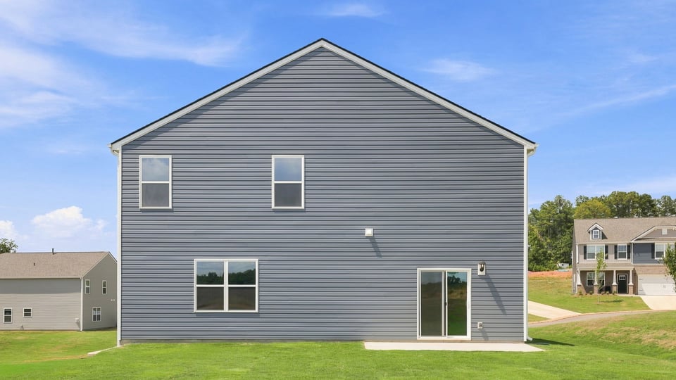 Back exterior of home with large backyard.