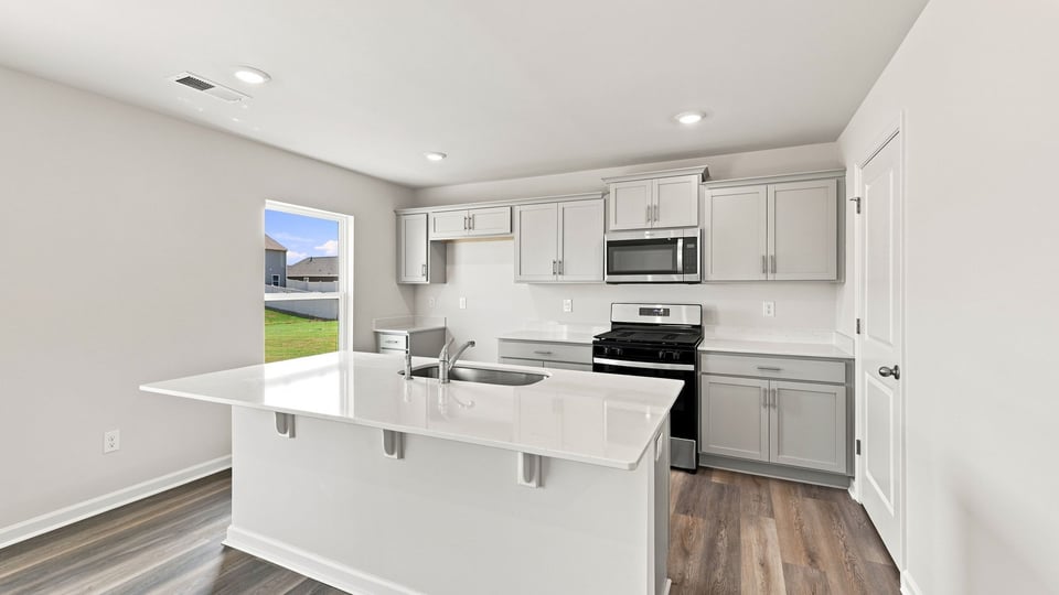 Kitchen and island with quartz countertops.