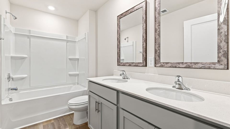 Bathroom with double vanity sink and bathtub.